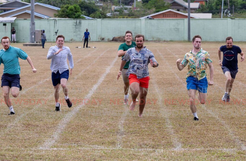 English visitor Alex Lane, 24, centre, wins a friendly 100m race against his Rums London Rugby Team colleagues at Mt Pleasant Sports and Family Day on Monday at the Mt Pleasant Recreation Ground. - Photo by David Reid