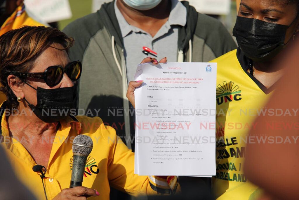 Opposition leader Kamla Persad Bissessar holds up what she says is a confidential TTPS memo as she addressed supporters at the Debe roundabout as they stage protest action over the increase in the cost of fuel at the pump. - Lincoln Holder