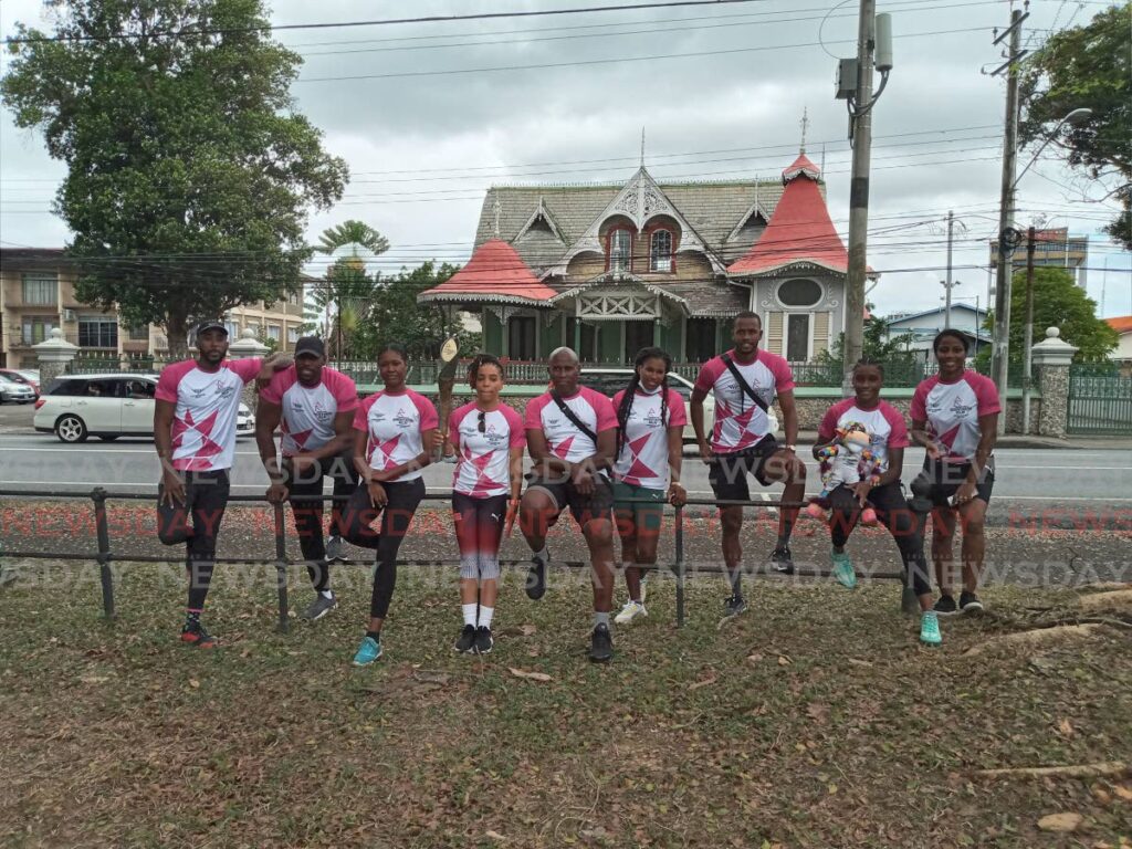 TT women's boxer Tianna Guy, fourth from left, holds the Queen's Baton at the Queen's Park Savannah in Port of Spain, on Wednesday. She is joined by national athletes and former athletes.  - Jelani Beckles