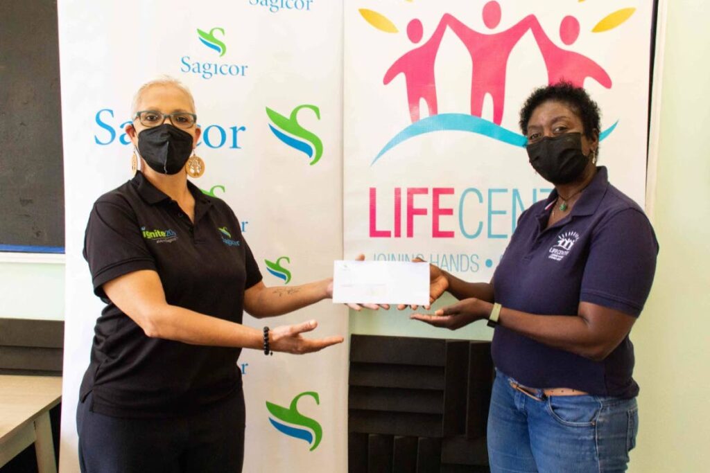Paula Araujo-Wilson, left, Sagicor’s operations manager in employee benefits, presents a cheque to Life Centre’s programme coordinator Lillon Ryan-Dick. - 