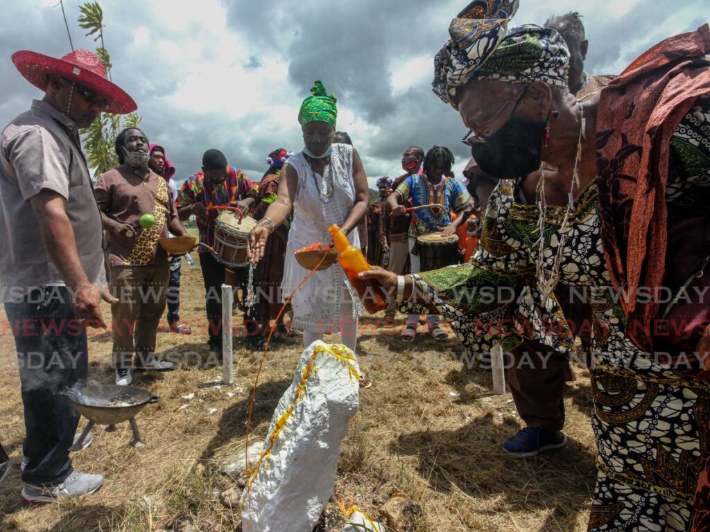 A member of the Council of Orisha Elders make an offering at a shrine at the Lopinot ancestral ground celebrate Friday to celebrate Earth Day. - Angelo Marcelle