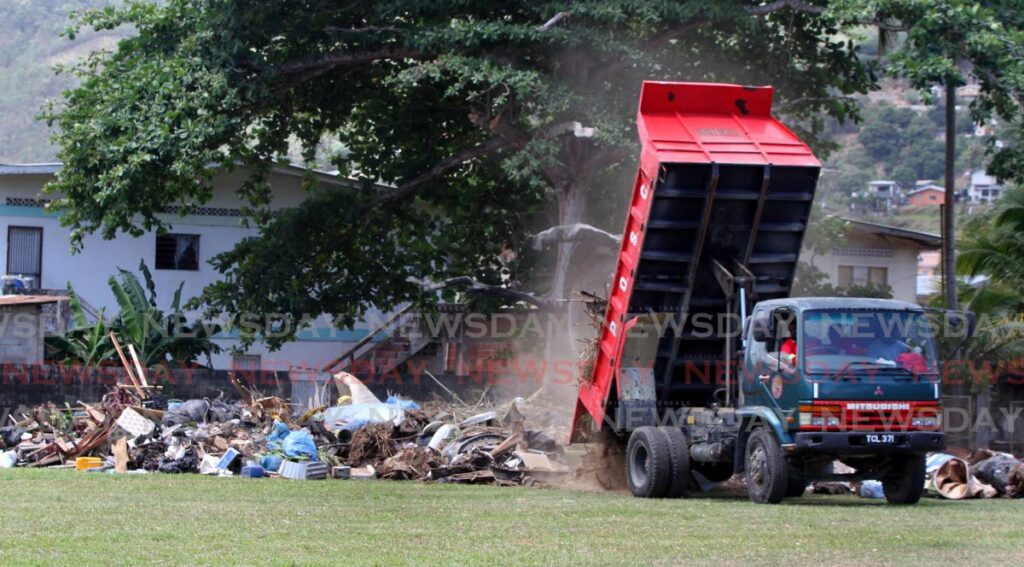 A truck dumps debris at Surprise Grounds, St Lucien Road, Diego Martin on Saturday, one of the collection sites, at the start the national clean-up campaign. - Angelo Marcelle