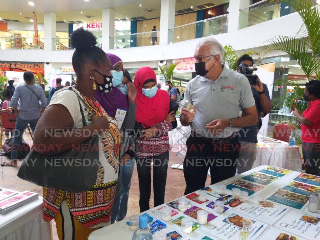 Health Minister Terrence Deyalsingh speaks with shoppers at Trincity Mall about the concentration of sugar in different types of food during a health fair at the mall on Saturday. - Tyrell Gittens