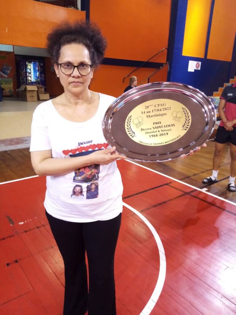 Jeromaine St Louis, wife of late five-time Caribbean table tennis champion Dexter St Louis, with the 20th French Antilles Table Tennis Championships trophy, held in tribute of the former TT player.  Photo courtesy Rheann Chung