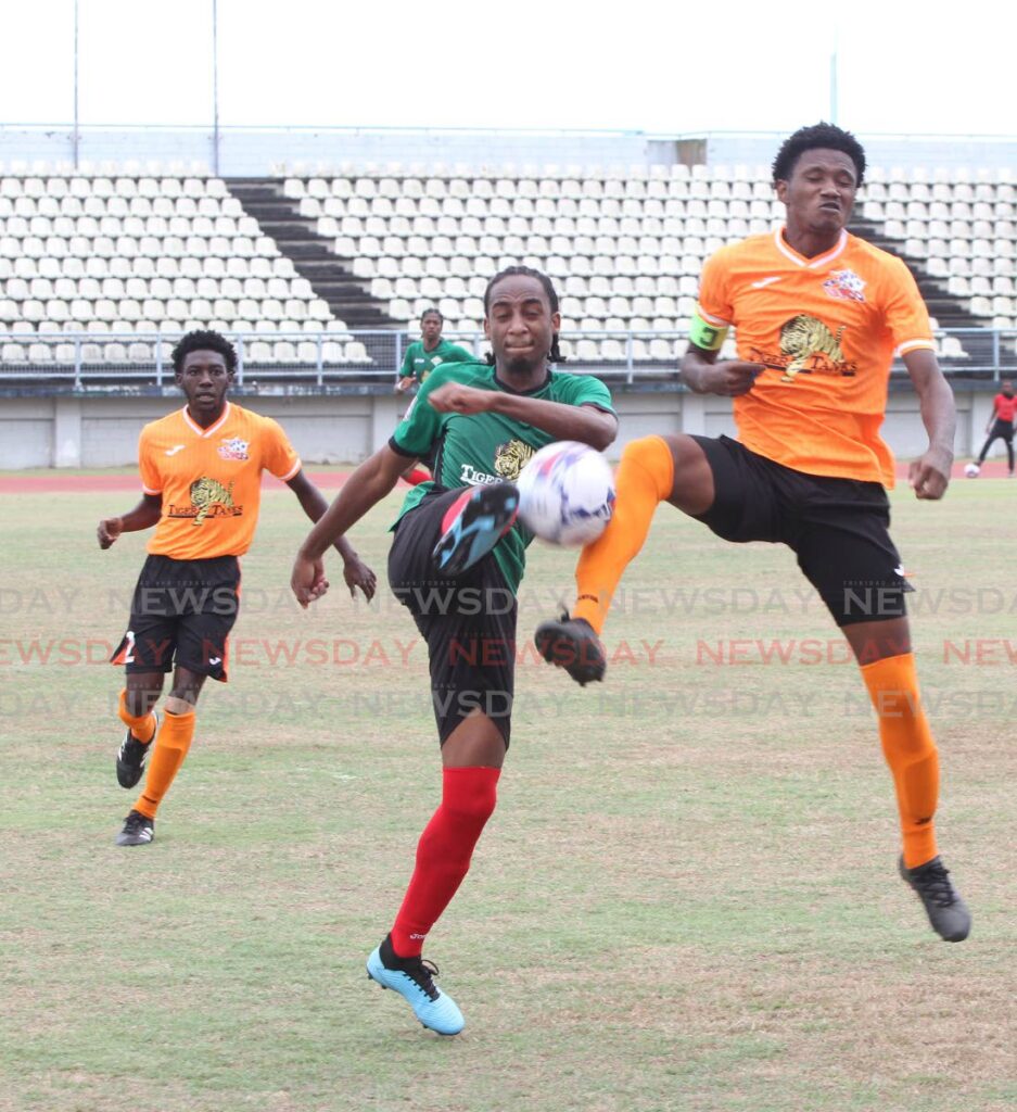 Shakeem Hospedales of San Juan Jabloteh and  Club Sando captain Marvin Waldrop (R) challenge for the ball during their Tiger Tanks Men’s U20 Invitational Football Tournament at the Larry Gomes Stadium, Malabar on Saturday. Photo by Angelo Marcelle