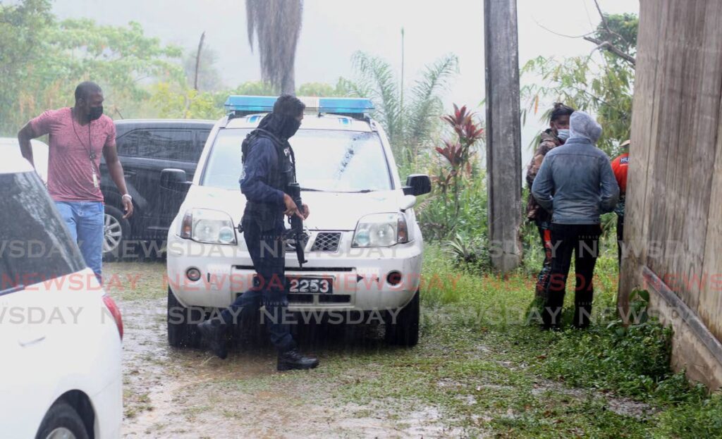 Police officers at the scene where three bodies were found in the space of 24 hours down a precipice at North Coast Road, Maracas on Tuesday. - 