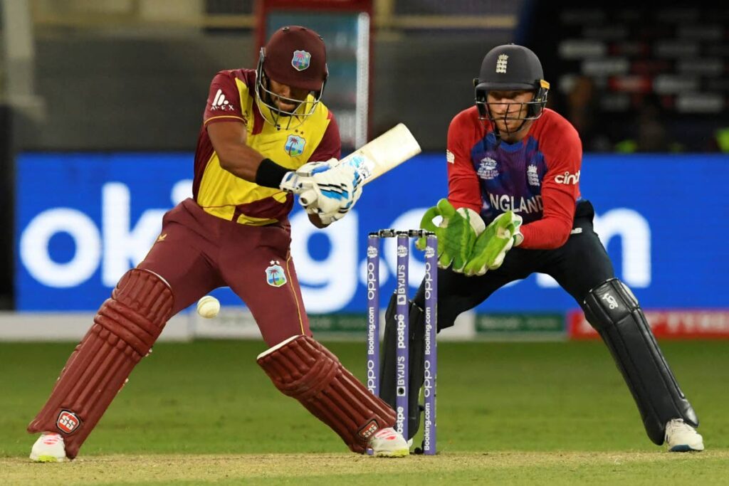 In this October 23, 2021 file photo, West Indies’ Nicholas Pooran  plays a shot as England’s wicketkeeper Jos Buttler watches during the ICC Twenty20 World Cup match at the Dubai International Cricket Stadium in Dubai, United Arab Emirates.  