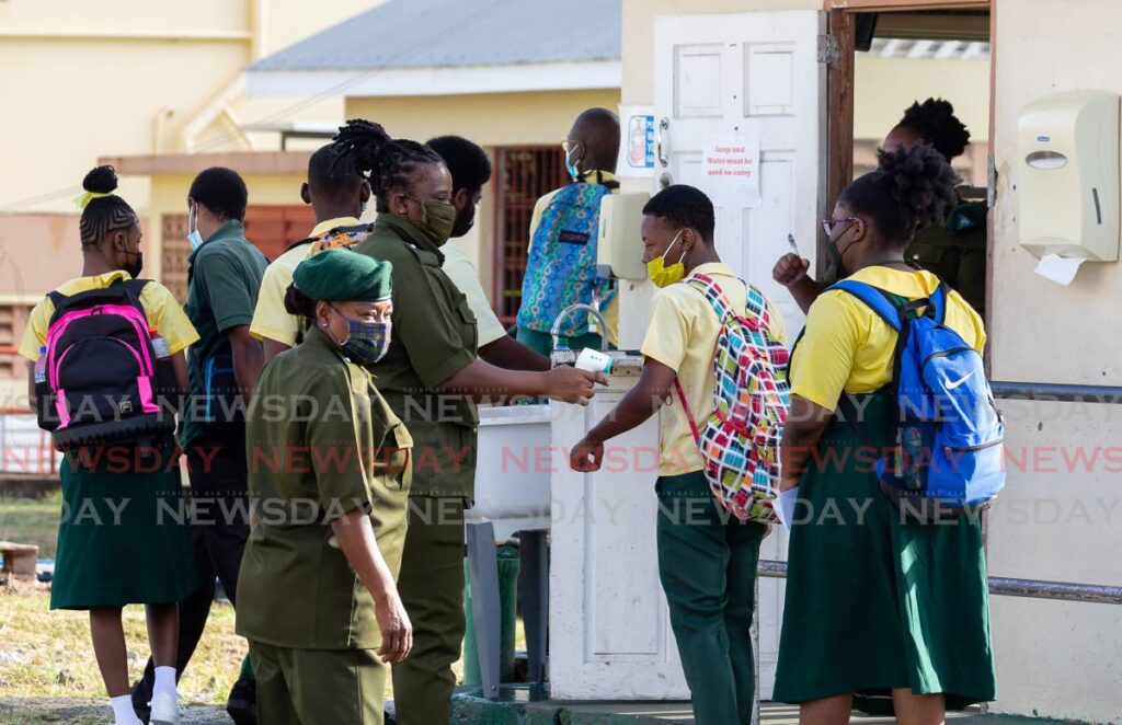 File photo: Signal Hill Secondary students get their temperature checked by security at the school compound. 
