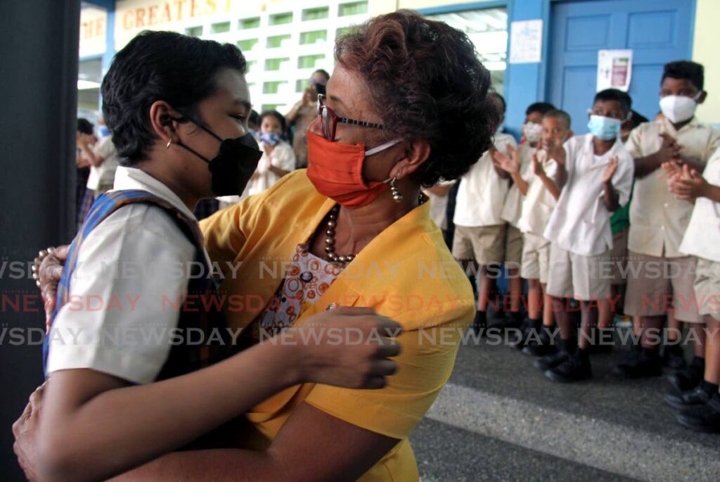 Sidara Akalloo (left) gets a hug from principal Donna Ramjohn-Khan at the Grant Memorial Presbyterian Primary School after completing the SEA exam at Presentation College, San Fernando, on April 21. Photo by Ayanna Kinsale