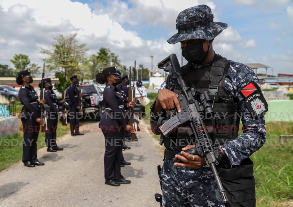 GEB officer stands guard ahead of a detachment at the burial site of PC Clarence Jefferson Gilkes at the Tunapuna Public Cemtery, Tunapuna on April 30. - JEFF K MAYERS