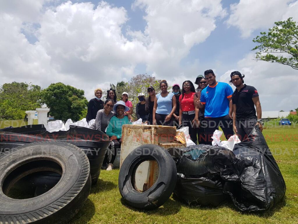 Smiles from Rotaract members after cleansing the mangrove of  tires, discarded appliances, to allow it to breathe and engage in carbon capture. PHOTO BY YVONNE WEBB - 