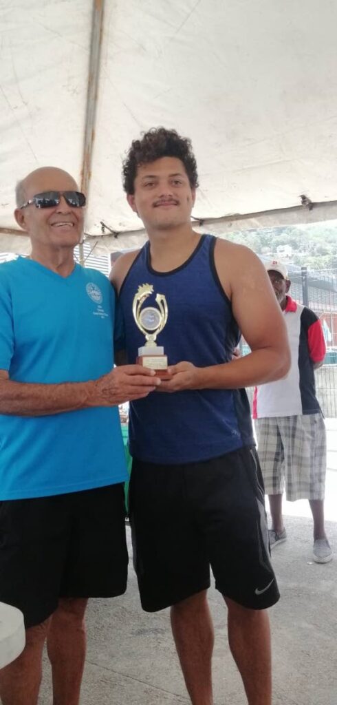 Josiah Parag, right, collects a trophy from Gordon Borde. Parag broke a 60-year swim record held by Borde.  - 