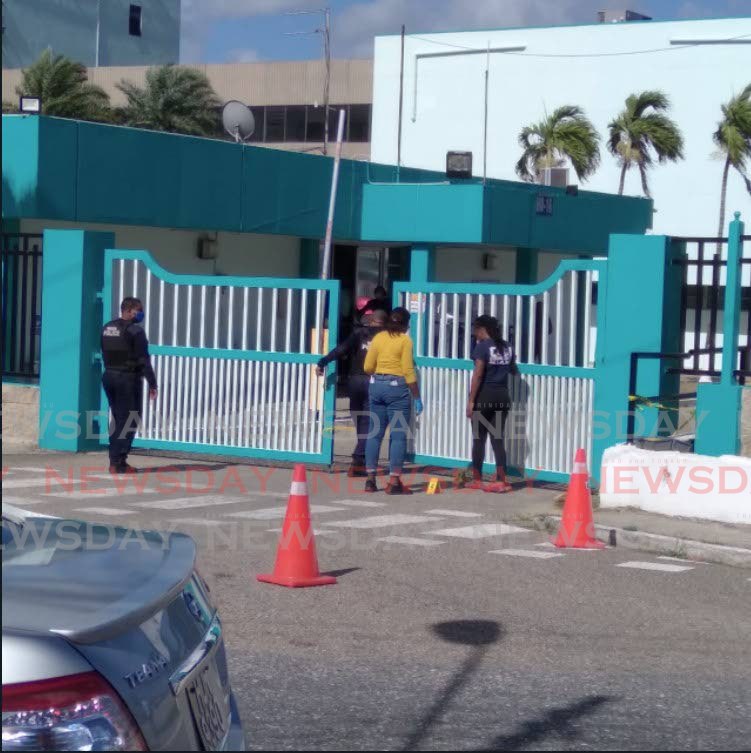 CRIME SCENE: Police interact with members of the public hours after a shooting incident at the St Joseph head office of the Water and Sewerage Authority (WASA) in which a worker was shot on Tuesday morning. Photo by Shane Superville