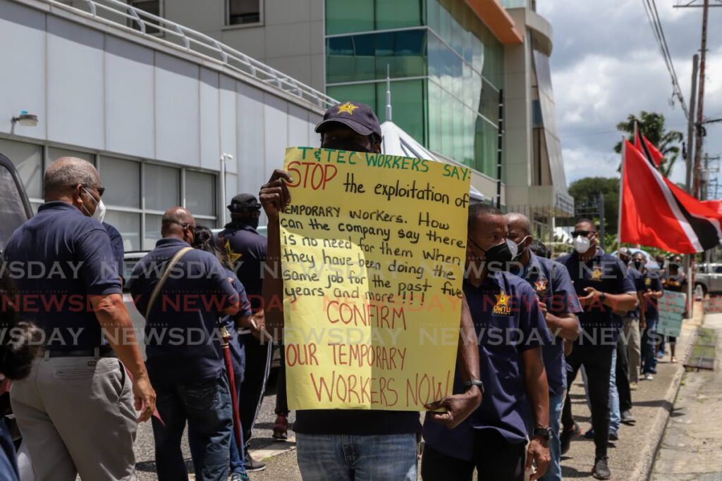 OWTU members protest for the full-time employment of TTEC temporary workers outside the Ministry of Public Utilities in Port of Spain on Tuesday. - JEFF K MAYERS