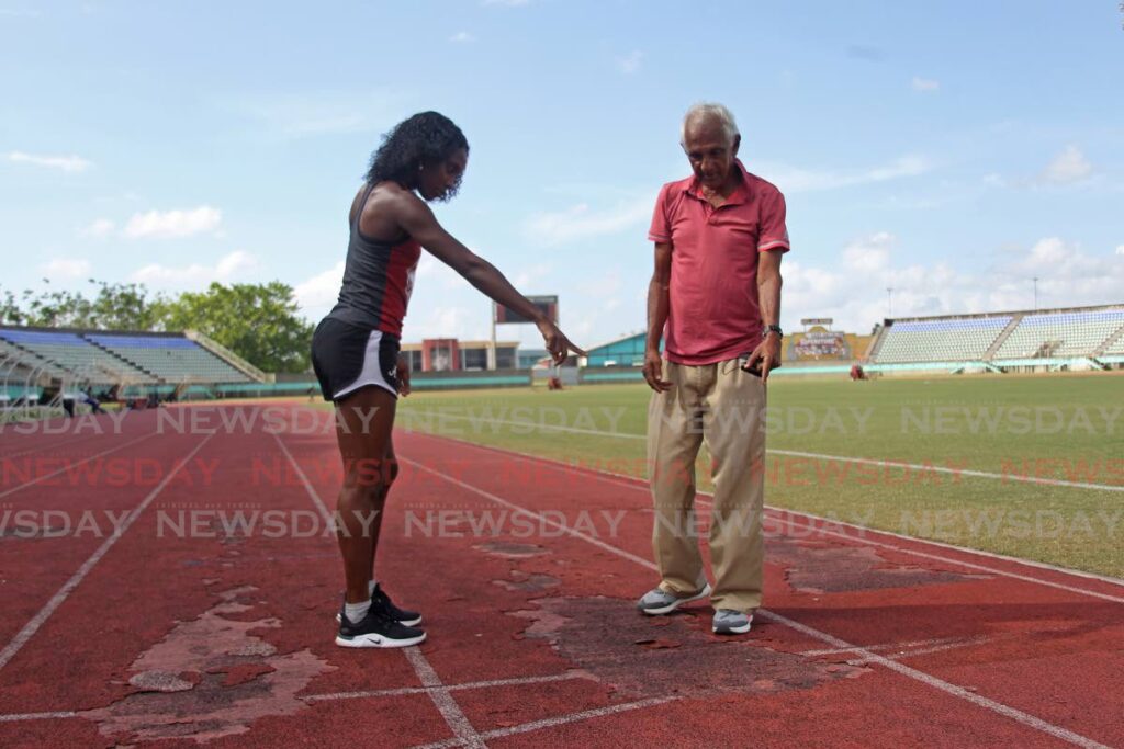 Simplex Athletic Club head coach Gunness Persad and athlete Mauricia Prieto discussing the state of the track at Manny Ramjohn Stadium on Thursday. Photo by Marvin Hamilton