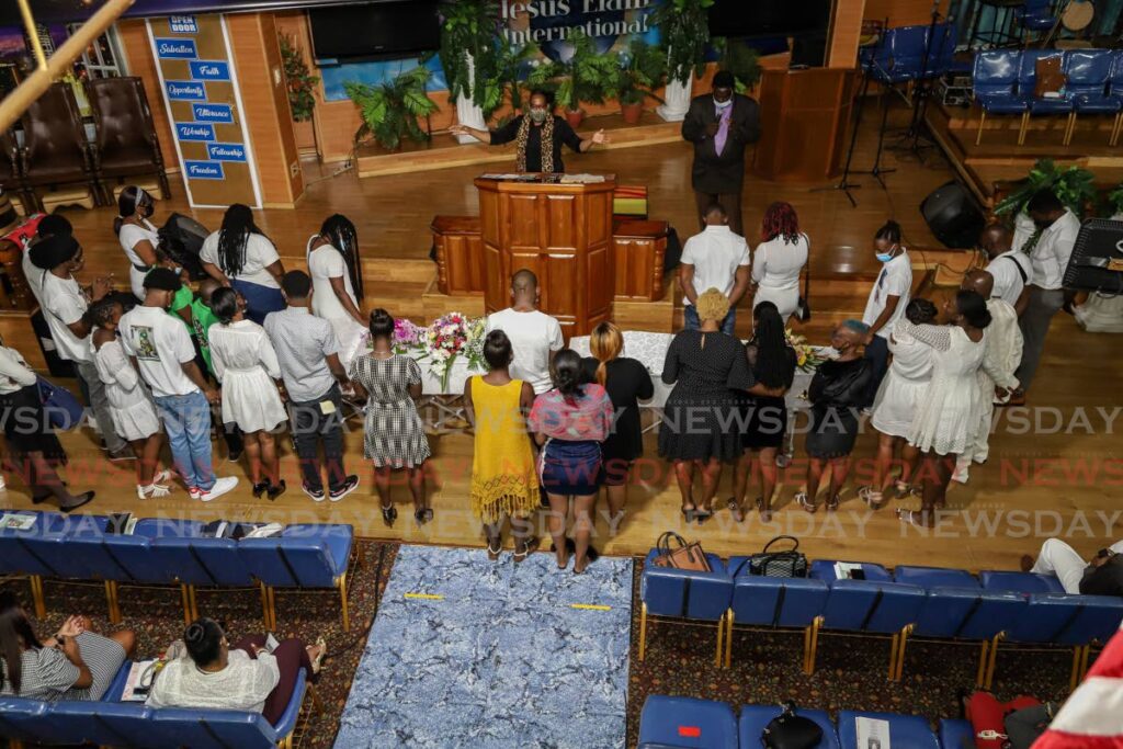 Familly members at the joint funeral for Norva Le Maitre and her nephew Kwasi Parris at the altar as the congregation prayed for the family at the Jesus Elam Revival Assembly International, San Juan on May 13. - PHOTO BY JEFF K MAYERS