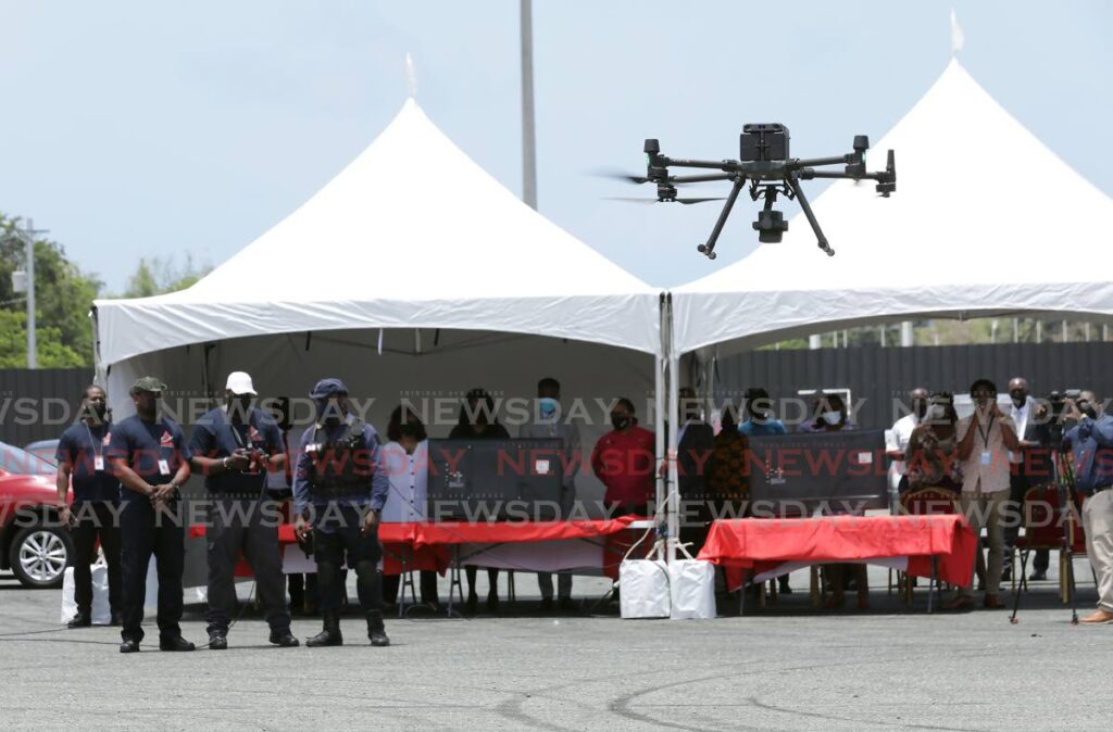 Officials of TEMA, IDB, the THA and the The Ministry of Digital Transformation look on during demonstration of the capability of a drone donated to TEMA by the IDB as part of a $728,000 package at the Dwight Yorke Stadium on Friday.  PHOTO COURTESY THE THA - 