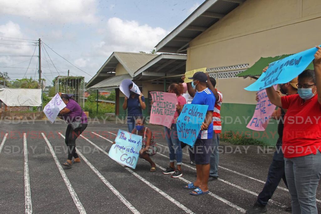WE WANT A NEW SCHOOL: Parents protest outside the dilapidated St Dominic’s RC School in Penal on Tuesday. Photo by Marvin Hamilton