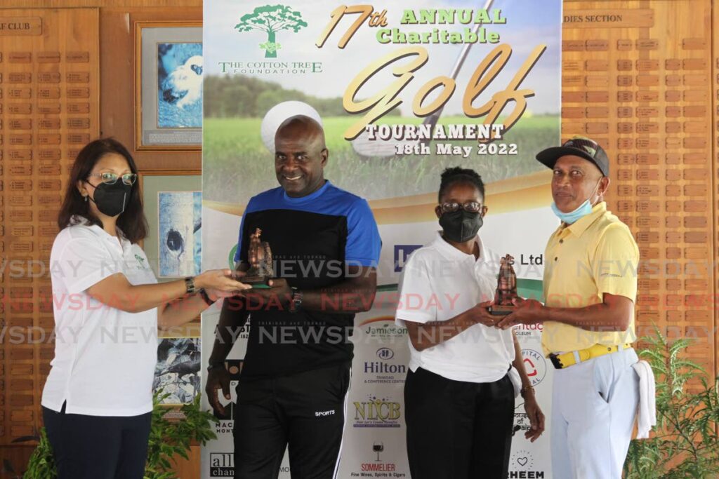 Curtis Moses (second from left) and Jerome Ali (right) collect their prizes from Sita Gajadhar-Persad (left) and Donna Frederick on Wednesday. Photo by Roger Jacob