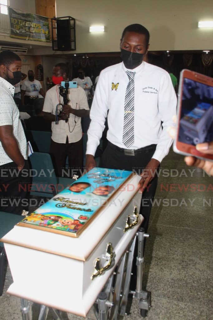 An attendant at Guide's Funeral Home with the casket of Kimani Francis during his funeral at Bethel Pentecostal Church, Point Fortin on May 20. - PHOTO BY ROGER JACOB