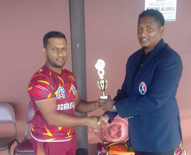 Nicholas Sookdeosingh  collects the Man-of-the-Match award from Anderson Ramdath, an executive member of the Trinidad and Tobago Cricket Board, on Saturday at the National Cricket Centre, Couva. - 