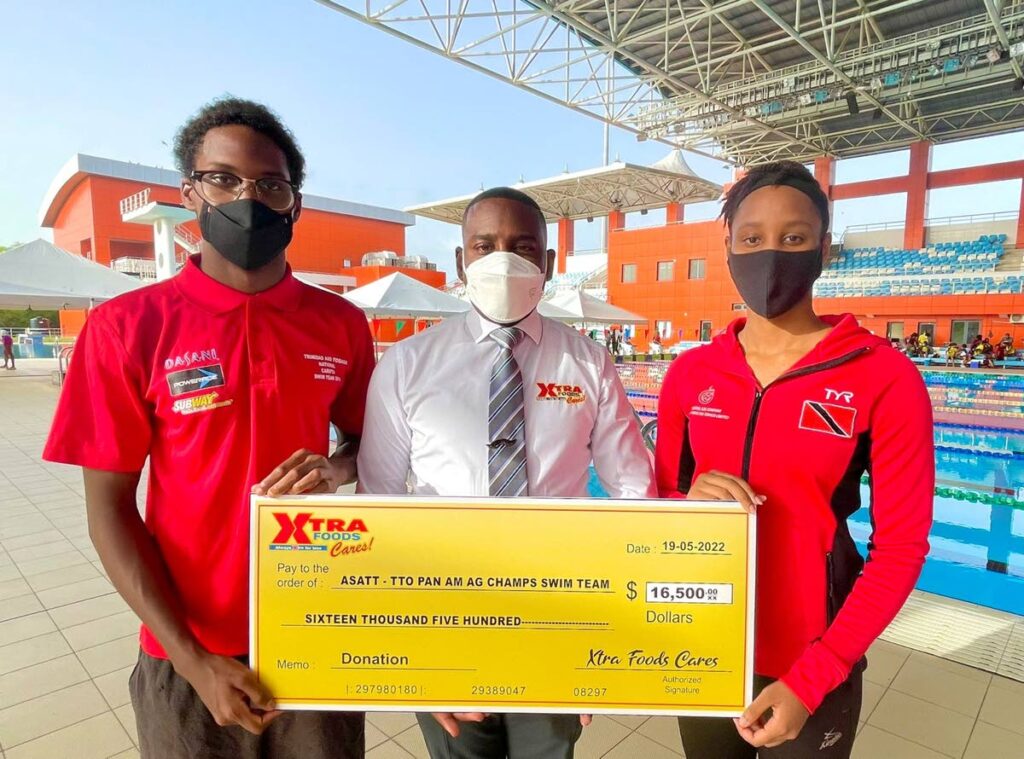 Daniel Austin, group marketing manager Xtra Foods, centre, presenting a cheque to
Johann Matthew Matamoro, left, and Jahmia Harley, captains of the TT swim team
at the National Aquatic Centre in Couva, on Thursday. 