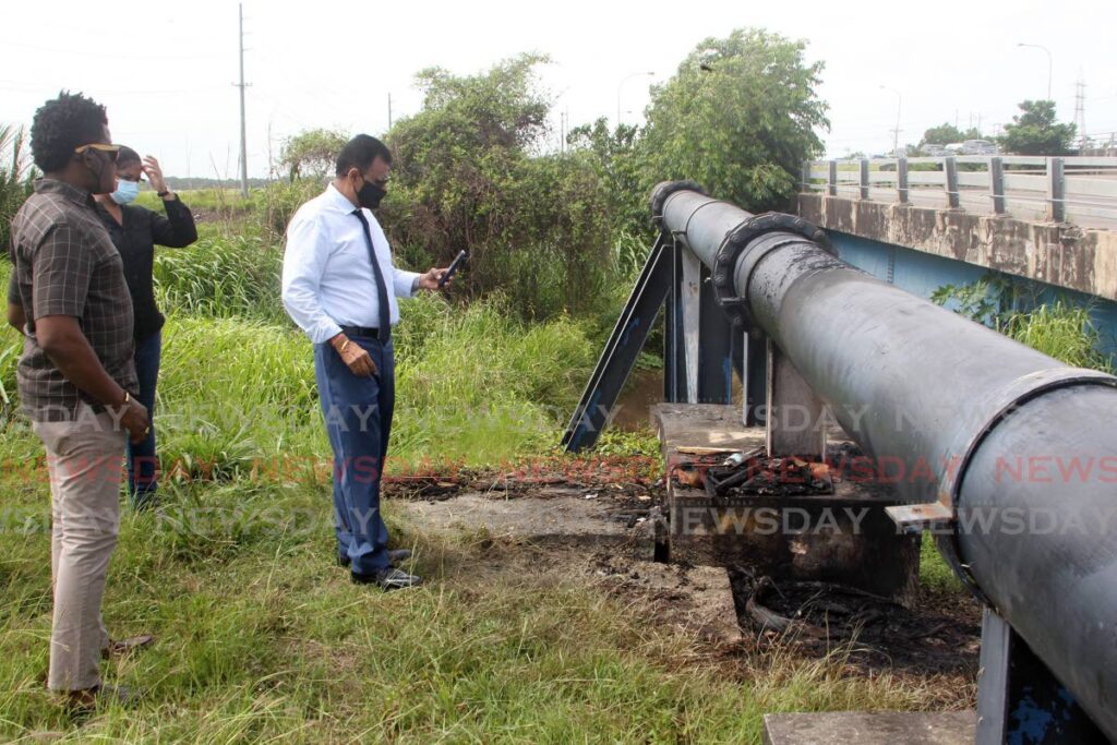 Minister of Works Rohan Sinanan and a technical team from the ministry examine damage to a pump, caused by an arson attack, at the Bamboo No 3 Pump Site on Thursday. Photo by Roger Jacob