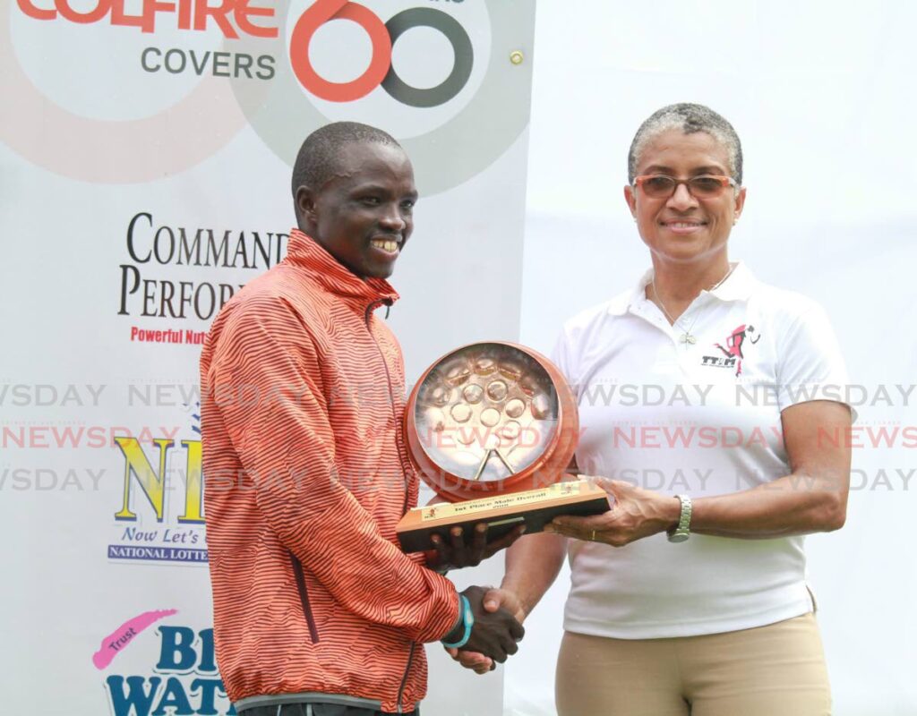 In this January 21, 2018 file photo, Stephen Mburi Njoroge collects the winners trophy from Dianne Henderson at the TT International Marathon. Henderson was elected the first female preisdent of the TT Olympic Committee, on April 30. - FILE PHOTO