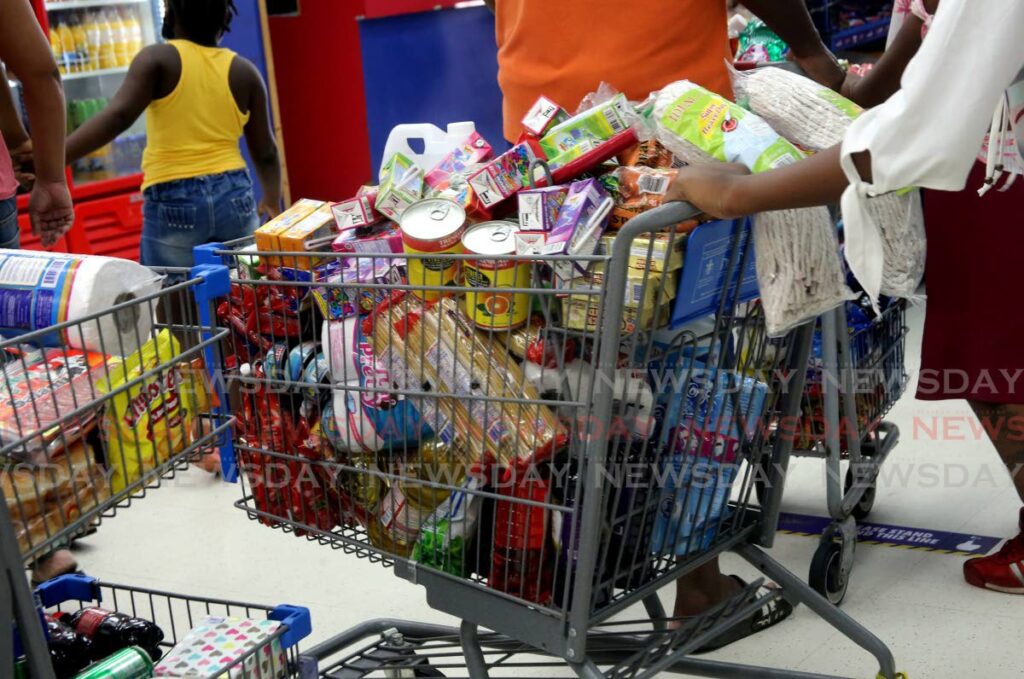 Shoppers stand in line to cash out at a supermarket in east Trinidad. - File photo