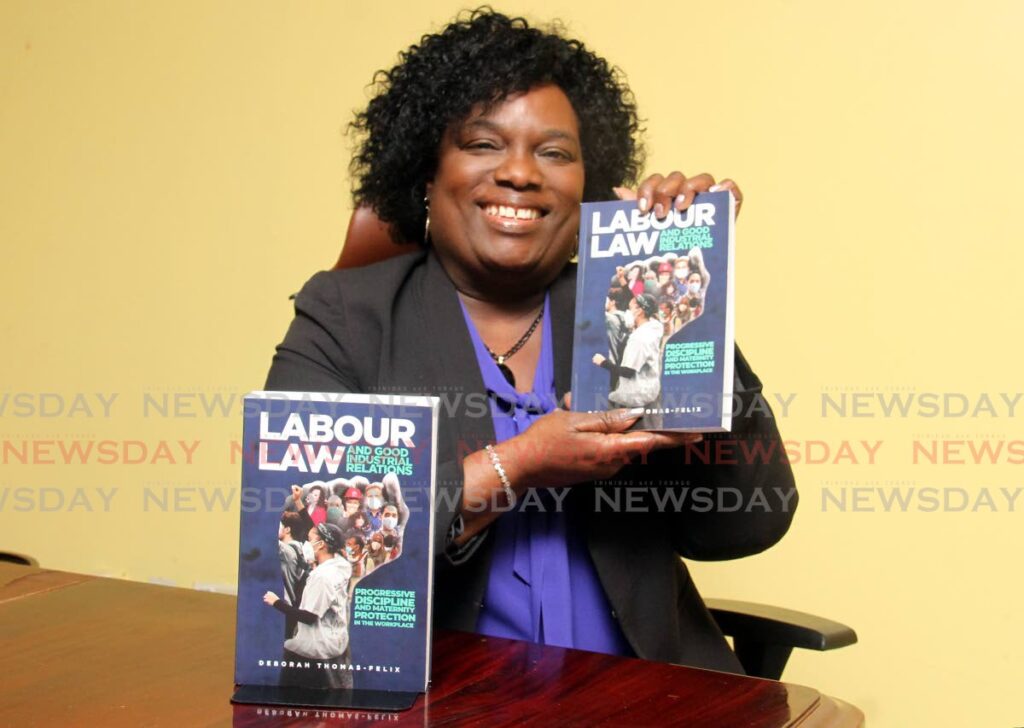 Industrial Court president Deborah Thomas-Felix shows off her latest book at the court on St Vincent Street, Port of Spain on Thursday. - Ayanna Kinsale