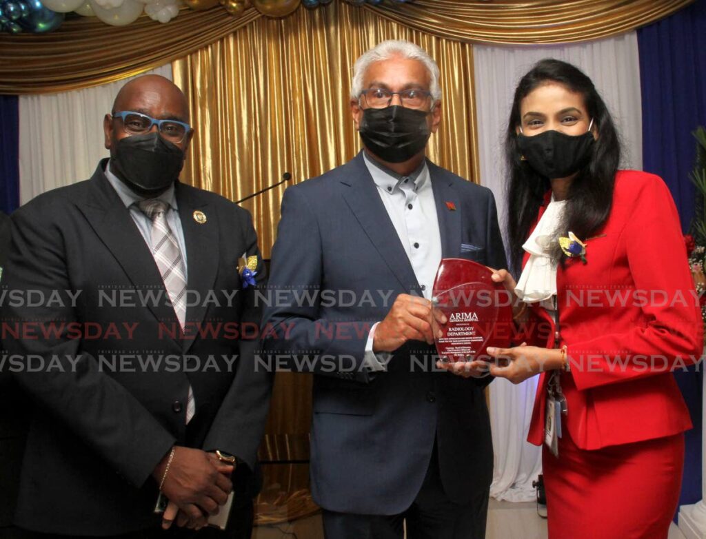 AWARDED: Health Minister Terrence Deyalsingh presents a plaque to Radiology Co-ordinator Shantee Mongroo during the recommissioning ceremony for the Arima Hospital on Sunday. At left is NCRHA CEO Davlin Thomas. Photo by Ayanna Kinsale