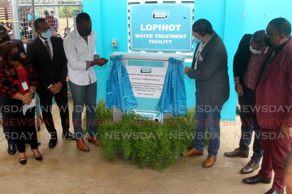 Minister of Public Utilities and Lopinot/Bon Air MP Marvin Gonzales, third from left, unveils a commemoratory plaque along with Communications Minister in the OPM Symon deNobriga as WASA officials look on at a commissioning ceremony for the Lopinot Water Treatment Facility La Pastora Branch Road, Lopinot. Photo by Roger Jacob