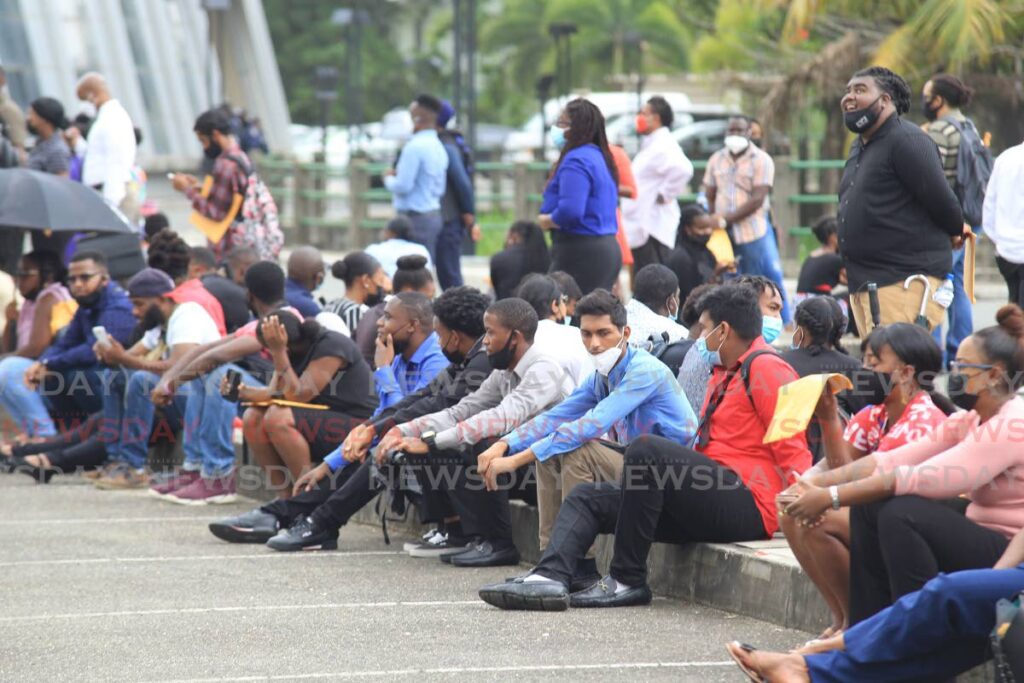 These people, among the hundreds who turned up at SAPA on Wednesday to apply for cruise ship jobs, take a rest after standing for long hours outside the venue. - Lincoln Holder