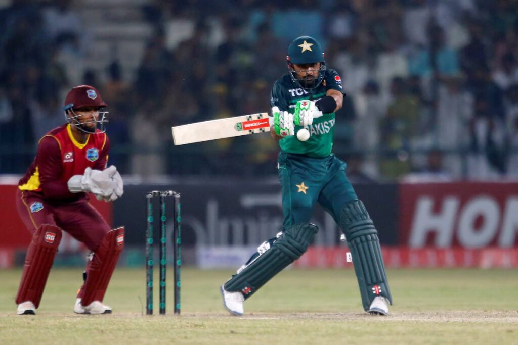 Pakistan's Babar Azam, right, plays a shot while West Indies captain Nicholas Pooran watches during the first one day international at the Multan Cricket Stadium, in Multan, Pakistan, on Wednesday. (AP Photo) 