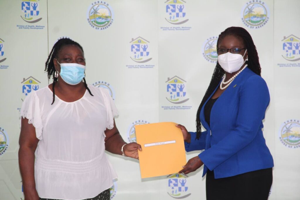 THA secretary Dr Faith BYisrael, right, presents a cheque to Paula Wright at the REACH grant distribution ceremony at the Division of Health, Wellness and Social Protection, Scarborough, Tuesday. - THA