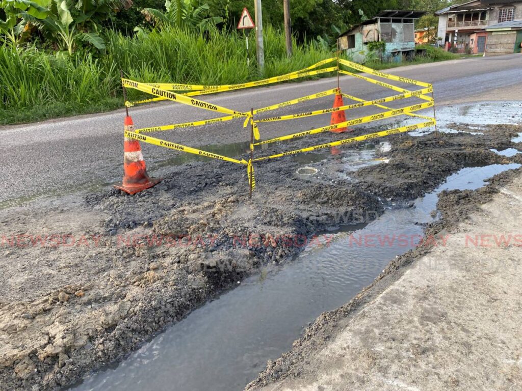 After a car got stuck in a pothole in Cochrane Village, Guapo, a WASA crew filled and cordoned off the area.  - Narissa Fraser