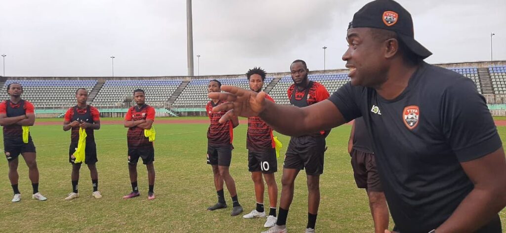 Trinidad and Tobago football team coach Angus Eve (right) gives instructions to his players during a training session at the Manny Ramjohn Stadium, Marabella on Sunday. PHOTO COURTESY TT FOOTBALL ASSOCIATION. - 