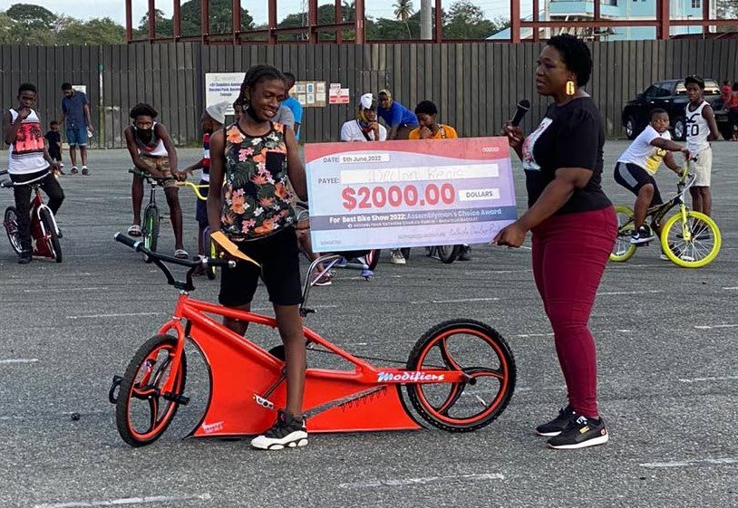 Assemblyman Nathisha Charles-Pantin, right, hands out the $2,000 cheque to Declon Regis, who won the Assembylyman's Choice award at the Best Bike Show, held at Parade Ground, Bacolet.  - 
