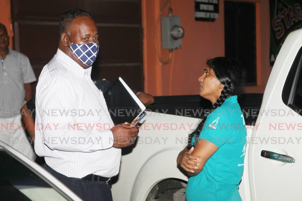 A Homicide region III officer speaking with Joanne Chance, sister of Nigel Chance  who was gunned down  alongside his wife Surita Deosaran at their St Mary's Moruga home on Wednesday night. - Photo by Lincoln Holder