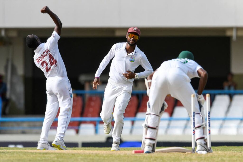 Kemar Roach (L) and Kraigg Brathwaite (C), of West Indies, celebrate the dismissal of Ebadot Hossain Chowdhury (R), of Bangladesh, during the third day of the 1st Tes at the Sir Vivian Richards Cricket Stadium in North Sound, Antigua, on Saturday. - 