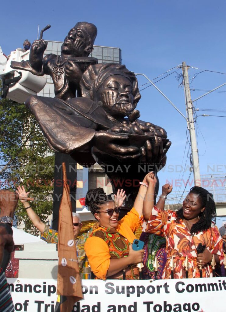 Maria Diaz, left, and Sherlann Peters rejoice at the unveiling of the Yoruba Village Monument on June 18.  Photo by Angelo Marcelle