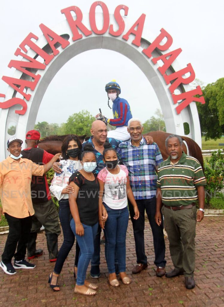 Affirmative, with his handlers, owners and jockey Dillon Khelawan (back) after winning the President's Cup at the Santa Rosa Park, Arima on Monday. - Angelo Marcelle