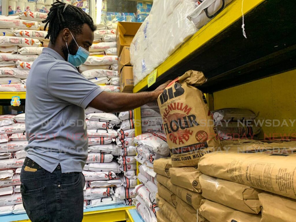 Israel Cujoe checks a 10kg sack of flour at Harris Megastore Supermarket, San Fernandon on Tuesday ahead of the increase in wholesale prices by NFM on Wednesday. - File photo/Marvin Hamilton