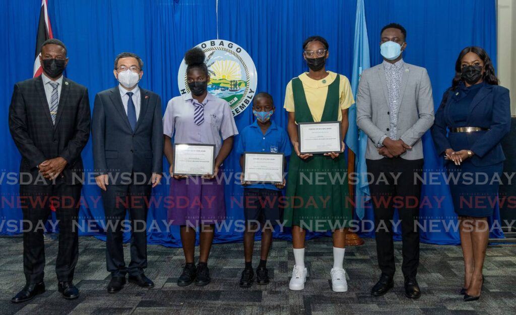 Students (from left to right) Kelissa Alvarez, Jahlil Baynes and Jenna Dick were awarded scholarships courtesy the Chinese Ambassador Scholarship Programme at the Victor E Bruce Complex, Scarborough on Wednesday. Also present at the ceremony were (from left) Assistant Education Secretary Orlando Kerr, Chinese Ambassador Fang Qui,  Chief Secretary Farley Augustine and Education Secretary Zorisha Hackett. Photo by David Reid