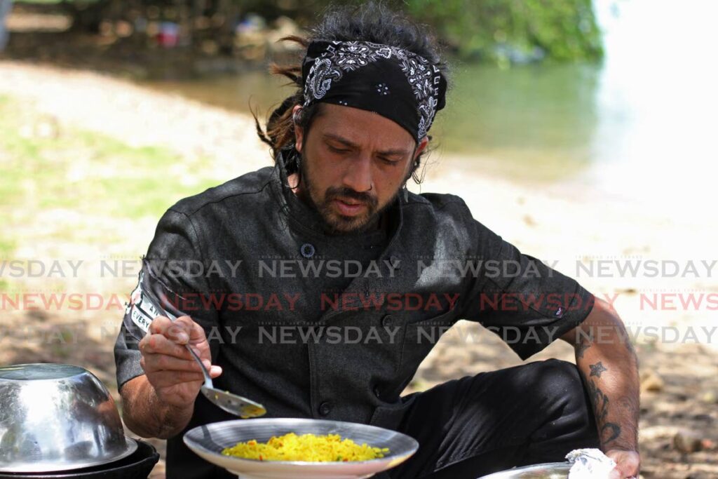 Chef Allan Bachan prepares a dish of safron and pimento rice at Flower Pot beach, Claxton Bay. Photo by Marvin Hamilton