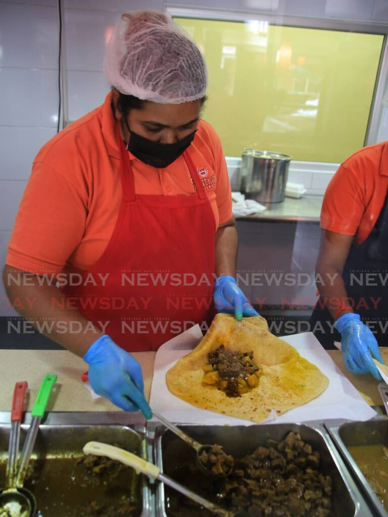 An attendant prepares a chicken roti for a customer at Patraj Roti Shop in San Juan on Wednesday. Photo by Sureash Cholai