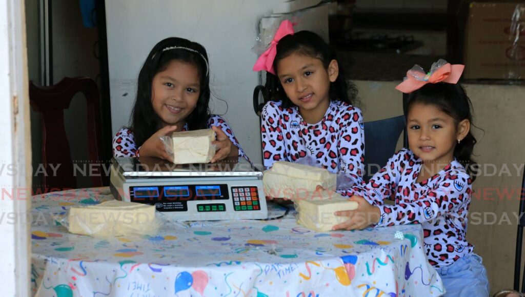 Sisters Argeilys, Geilysmar and  Genesis Lopez weigh white cheese at their home in Five Rivers, Arouca. Photo by Sureash Cholai