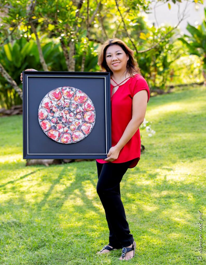 Artist Joy Luk Pat holds her painting Pan Ramajay Lifestyle. - 