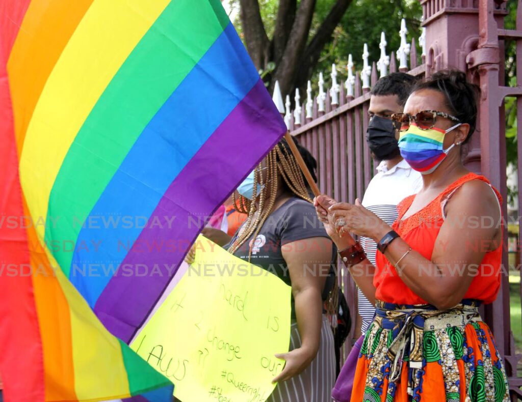 Women's Caucus of Trinidad and Tobago's Sharon Mottley waves her rainbow flag during the LGBTQI+ demonstration to celebrate Pride Month, opposite the Red House, Abercromby Street, Port of Spain, Friday.  - AYANNA KINSALE
