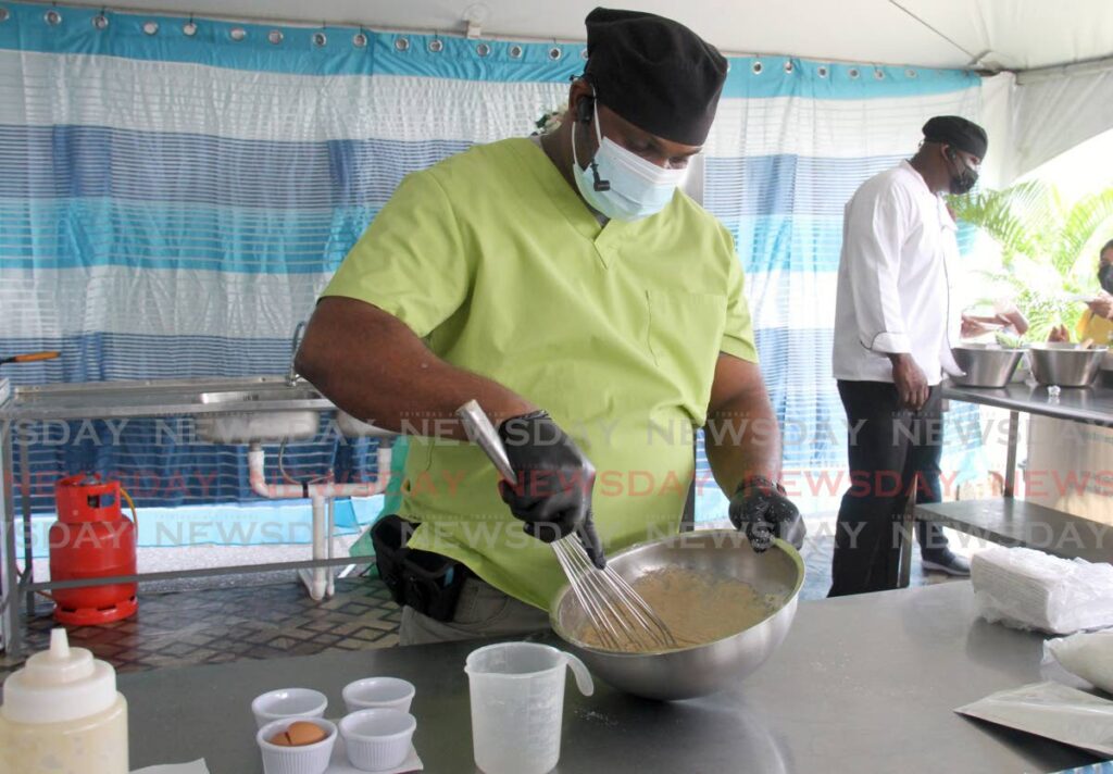 National Schools Dietary Services chef Sheldon Mason mixes pancake batter made with sweet potato flour at the Namdevco farmers market, Queen's Park Savannah, Port of Spain on Saturday. - AYANNA KINSALE